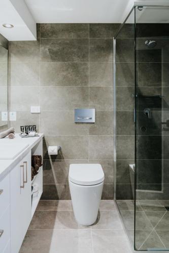 a bathroom with a toilet and a glass shower at Falls Creek Hotel in Falls Creek