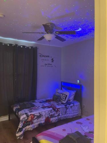 a room with two beds and a ceiling fan at Vashay's Lovely vacation pad at Disney in Davenport
