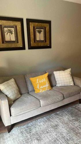 a gray couch with two pillows in a living room at Vashay's Lovely vacation pad at Disney in Davenport