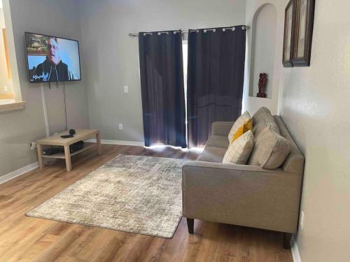 a living room with a couch and a tv at Vashay's Lovely vacation pad at Disney in Davenport