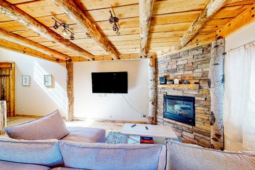 a living room with couches and a stone wall at Ponderosa Pine Place in Flagstaff
