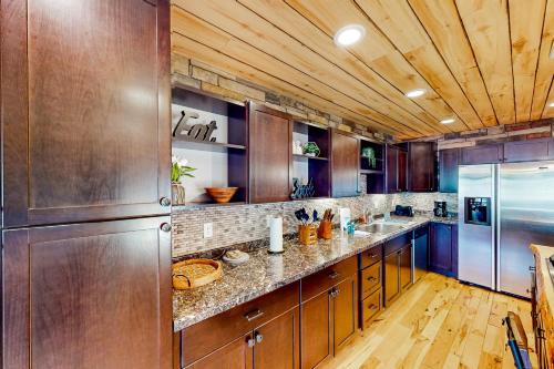 a large kitchen with wooden cabinets and a refrigerator at Ponderosa Pine Place in Flagstaff