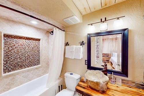 W łazience znajduje się wanna, toaleta i lustro. w obiekcie Ponderosa Pine Place w mieście Flagstaff