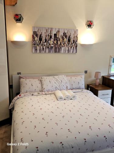 a bedroom with a bed with two towels on it at LONDON HEATHROW GLAMOUR MANSION HOUSE in Uxbridge
