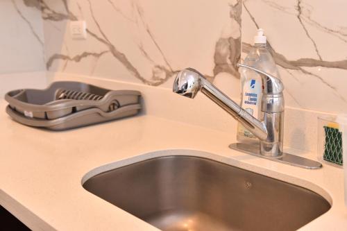 a sink with a faucet and a bottle of soap at Volcano Views Apartment in San Salvador