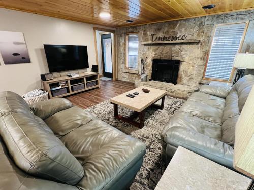 a living room with a leather couch and a fireplace at Dolly's # 1 condo in Sevierville
