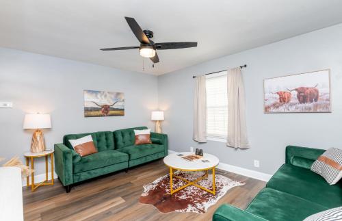 ein Wohnzimmer mit grünen Möbeln und einem Deckenventilator in der Unterkunft Urban Cottage-Bourbon Trail, Expo, YUM, Derby! in Louisville