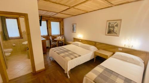 a hotel room with two beds and a bathroom at Locanda Al Cacciatore in Nervesa della Battaglia