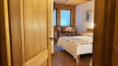 a bedroom with a bed and a table and a window at Locanda Al Cacciatore in Nervesa della Battaglia