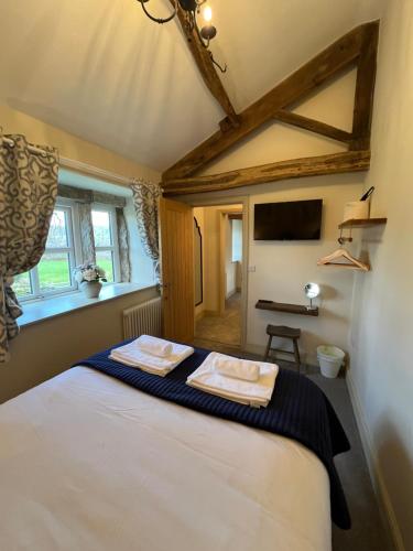 a bedroom with a bed with two towels on it at Bents Holiday Cottage in Oxenhope