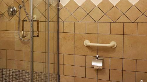 a bathroom with a shower and a toilet paper holder at Locanda Al Cacciatore in Nervesa della Battaglia