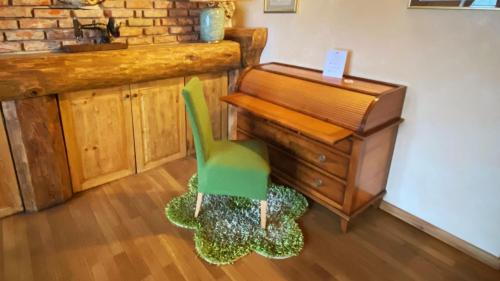 a green chair sitting in front of a desk at Locanda Al Cacciatore in Nervesa della Battaglia