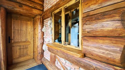 a wooden wall with a window in a log cabin at Locanda Al Cacciatore in Nervesa della Battaglia