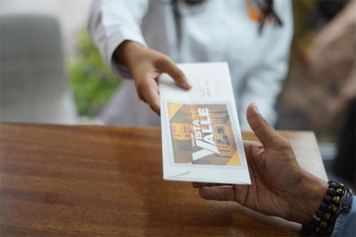 a person holding up a card with their hand at hotel vista valle in Tepic