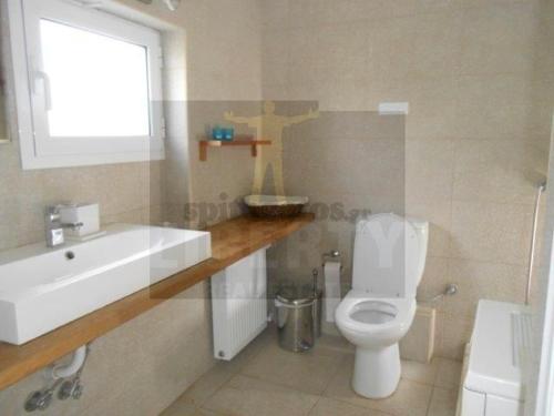 a bathroom with a white toilet and a sink at House on the beach G&M in Nea Makri