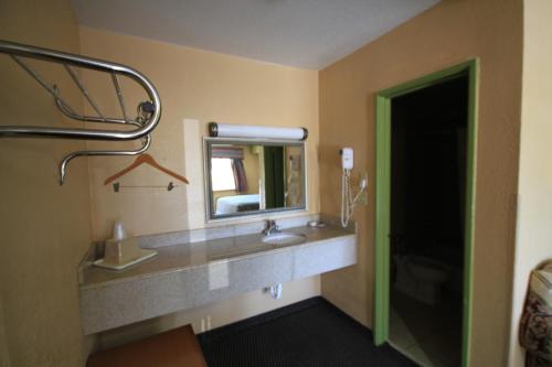 a bathroom with a sink and a mirror at Holiday Terrace Motel in Houston