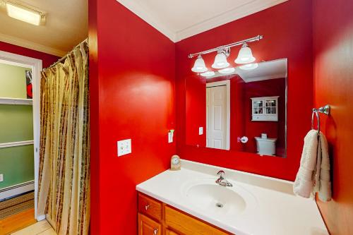 uma casa de banho vermelha com um lavatório e um espelho em Silver Springs em Falmouth