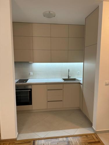 a kitchen with white cabinets and a sink at RS lux Becici in Becici