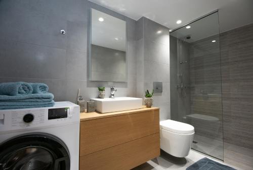 uma casa de banho com uma máquina de lavar roupa e uma máquina de lavar roupa. em Mylos Modern Apartments,By Idealstay Experience em Agios Nikolaos