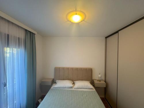 a bedroom with a bed with a light on the ceiling at RS lux Becici in Becici