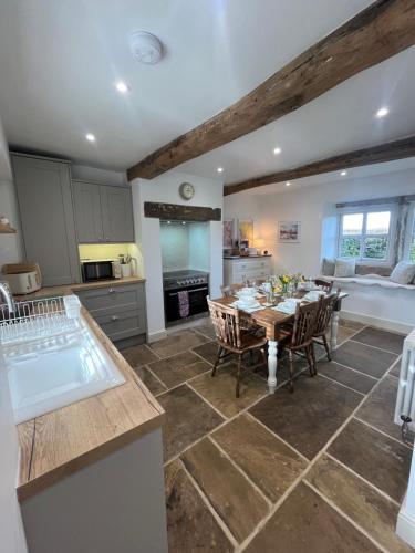 a kitchen and dining room with a table and chairs at Bents Holiday Cottage in Oxenhope