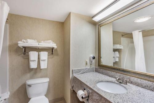 a bathroom with a toilet and a sink and a mirror at Best Western Danville Inn in Danville