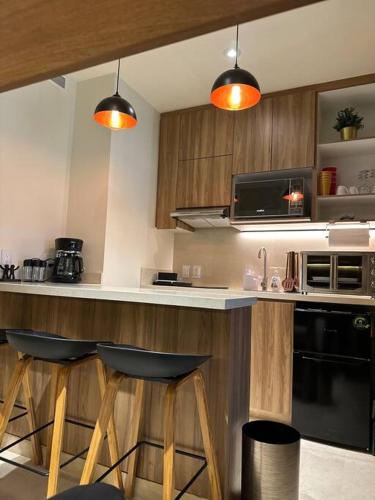 a kitchen with a counter and two stools in it at Zantamar New cozy beach front apartment in Cruz de Huanacaxtle