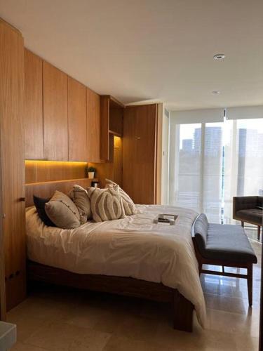 a bedroom with a large bed with wooden walls at Zantamar New cozy beach front apartment in Cruz de Huanacaxtle