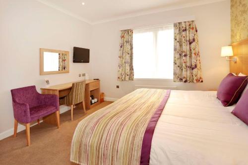 a hotel room with a large bed and a desk at Invercarse Hotel Dundee, BW Signature Collection in Dundee