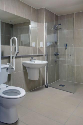 a bathroom with a shower and a toilet and a sink at Invercarse Hotel Dundee, BW Signature Collection in Dundee