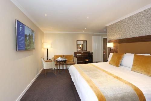 una camera d'albergo con un grande letto e una scrivania di Invercarse Hotel Dundee, BW Signature Collection a Dundee