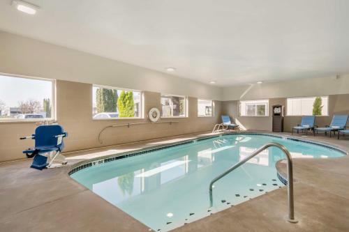 a swimming pool in a hotel room with chairs and tables at Best Western Inn of Vancouver in Vancouver