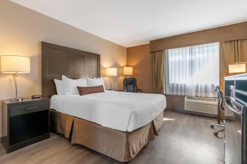 a hotel room with a bed and a television at Best Western Inn of Vancouver in Vancouver