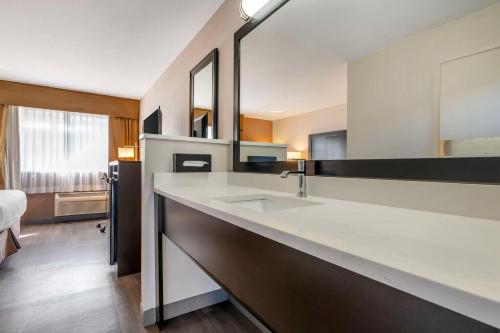 a bathroom with a sink and a large mirror at Best Western Inn of Vancouver in Vancouver