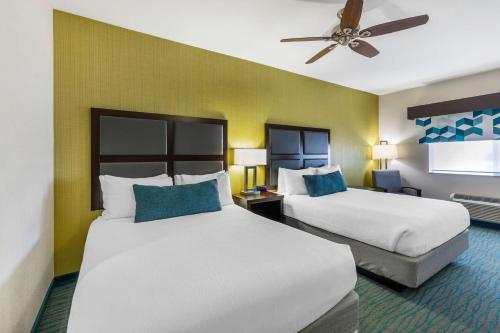 a hotel room with two beds and a ceiling fan at Best Western Plus Taft Inn in Taft
