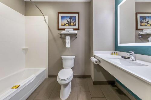 a bathroom with a toilet and a tub and a sink at Best Western Plus Taft Inn in Taft