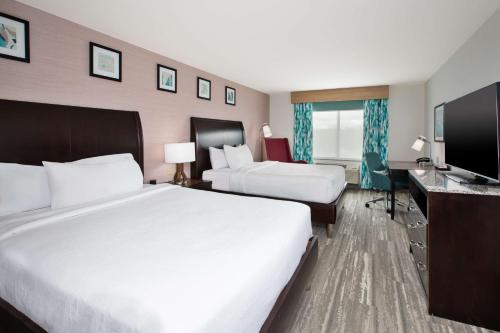 a hotel room with two beds and a flat screen tv at Hilton Garden Inn Benton Harbor in Benton Harbor