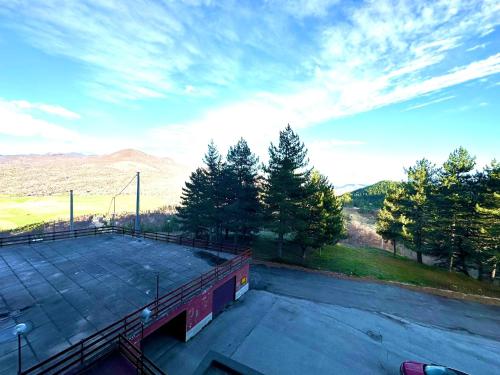 an empty parking lot with trees and mountains in the background at NWT Roccaraso - Casa Vacanze in Roccaraso