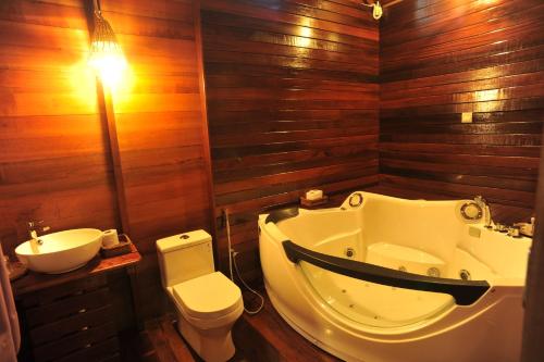 a bathroom with a tub and a toilet and a sink at Borneo Natural Sukau Bilit Resort in Bilit
