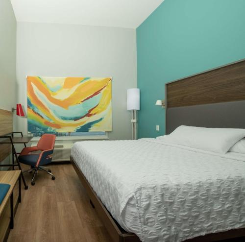 a bedroom with a bed and a desk and a chair at Tru By Hilton The Colony in The Colony