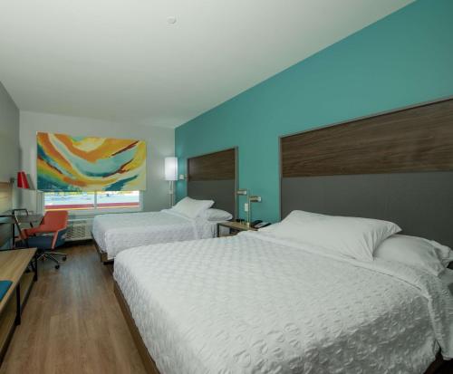 ein Schlafzimmer mit 2 Betten und einer blauen Wand in der Unterkunft Tru By Hilton The Colony in The Colony