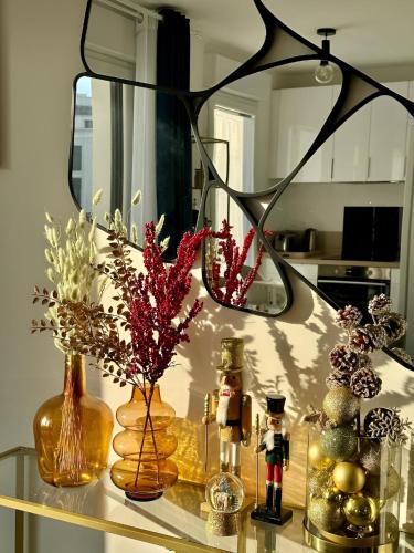a glass table with vases and decorations on it at Disneyland-PARIS Sunshine - 6pers - Terrasse - vue sur Parc - 2Parkings in Chessy