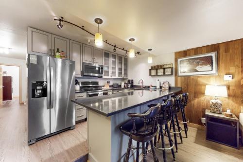 a kitchen with a refrigerator and some bar stools at North #409 in Anchorage