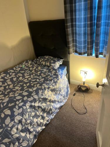 a bedroom with a bed and a lamp next to a window at Mortiara in Darlington