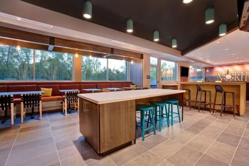 a restaurant with a bar and some chairs and tables at Tru By Hilton Northlake Fort Worth, Tx in Northlake
