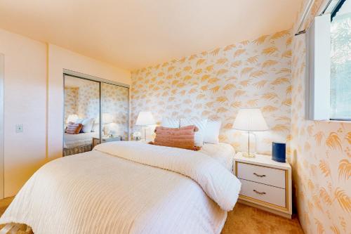 1 dormitorio con cama blanca y ventana en Toucan Sands, en Palm Springs