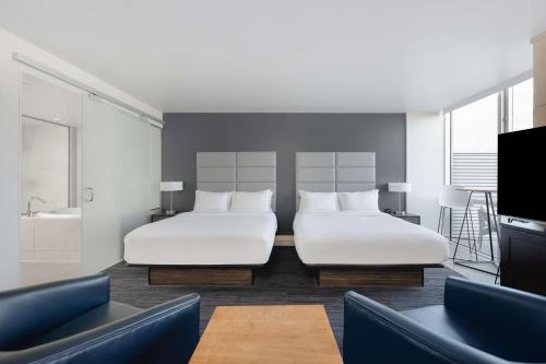Cette chambre dispose de 2 lits, d'une télévision et d'une salle de bains. dans l'établissement Hotelvetro Iowa City, Tapestry Collection By Hilton, à Iowa City