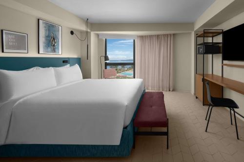 a hotel room with a large bed and a desk at ROK Hotel Kingston Tapestry Collection By Hilton in Kingston
