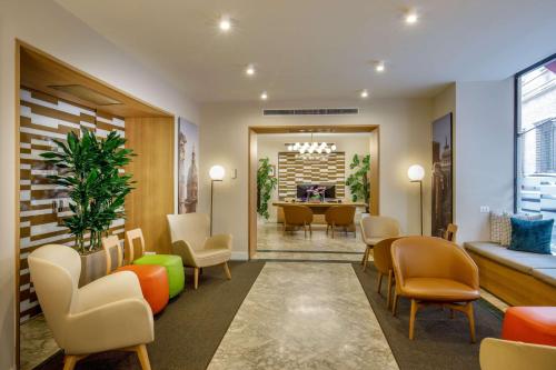 - une salle d'attente avec des chaises et une table dans l'établissement Cosmopolita Hotel Rome, Tapestry Collection by Hilton, à Rome