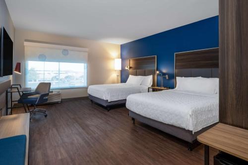 a hotel room with two beds and a desk at Tru By Hilton Naperville Chicago in Naperville